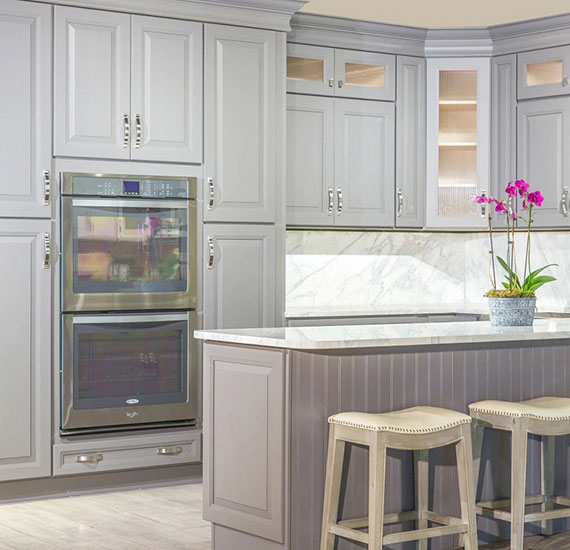 Light gray kitchen cabinets with light granite countertops.